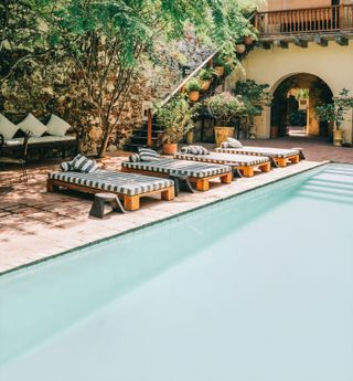 Image may contain Architecture Building Hotel Resort House Housing Villa Plant Pool Water Chair and Furniture