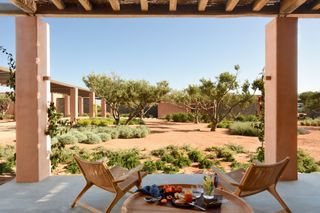 Image may contain Architecture Building House Housing Villa Chair Furniture Porch Patio Cup Desk Table and Plate